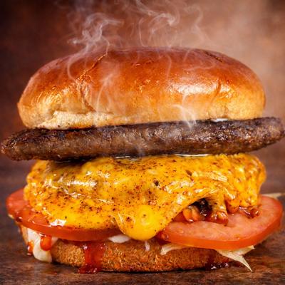 Gyro Burger served with a lamb gyro patty, a beef patty, cheese, lettuce, tomato, pickled onion, mayo and ketchup.