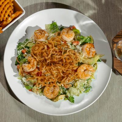 Shrimp salad, with lettuce, cheese, onions, tomatoes, and crispy onions.