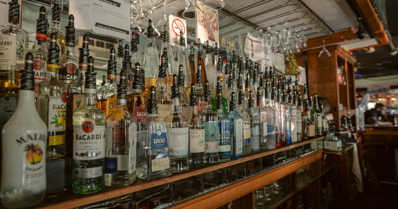 Close-up of a well-stocked bar shelves with variety of liquor bottles