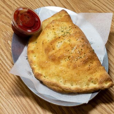Cheese calzone served with marinara sauce on the side.