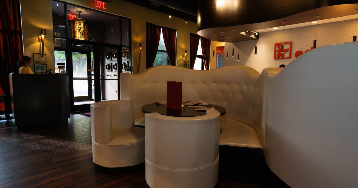 Interior of a stylish restaurant with white leather seating and warm lighting