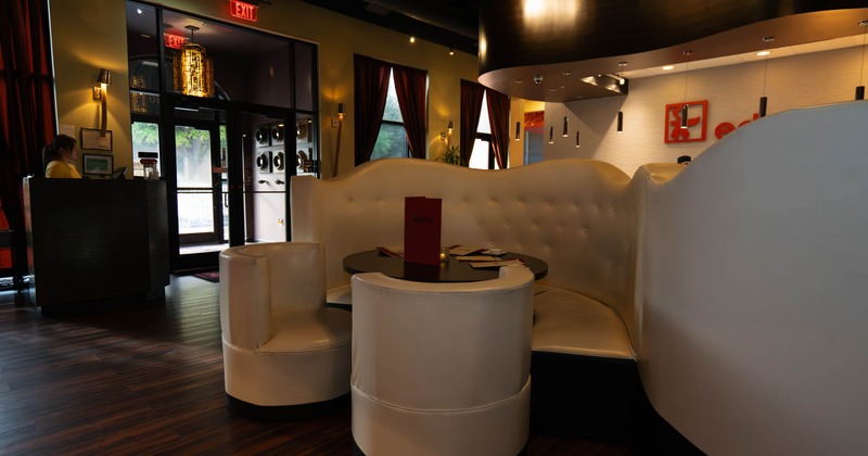 Interior of a stylish restaurant with white leather seating and warm lighting