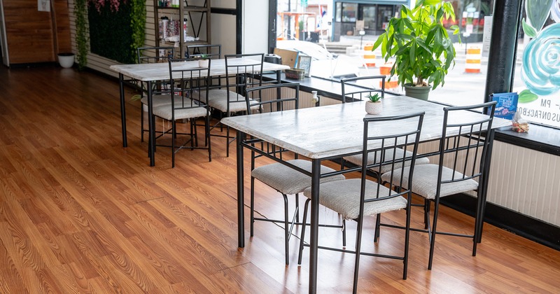 Interior space, seating area, two tables for four guests by the window