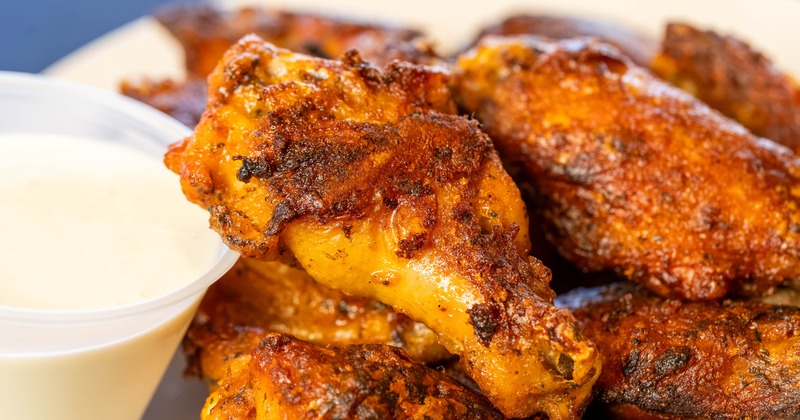 Chicken wings served with a side of white dipping sauce