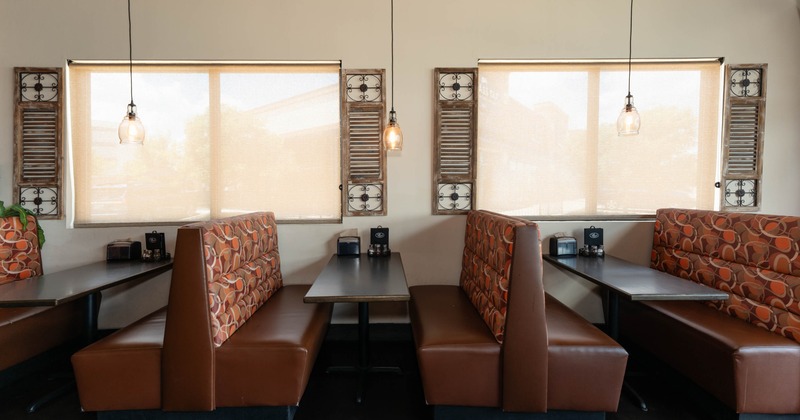 Interior, dining area, seating booths with wooden top tables, windows with blinds