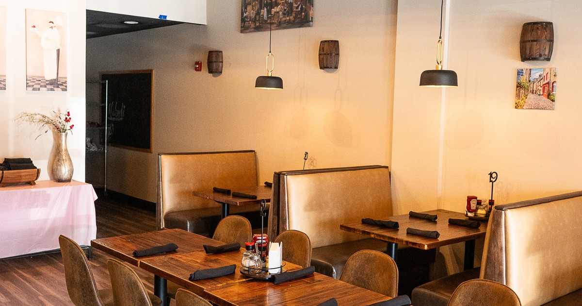 Cozy and modern interior dining area with upholstered booth seats along the wall and a dining table
