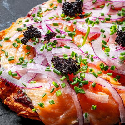 Flatbread topped with smoked salmon onions chives and roe.