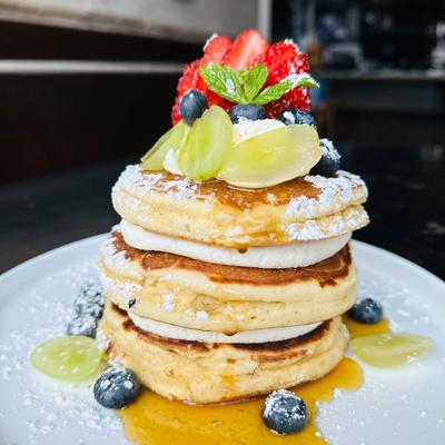 A stack of pancakes topped with fruits.