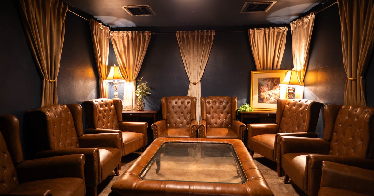 Interior, private lounge area, leather padded armchairs set up in circle, low table