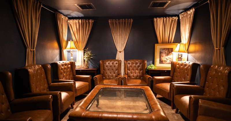 Interior, private lounge area, leather padded armchairs set up in circle, low table