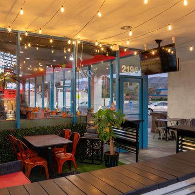 Seating area with potted plants and artificial grass floor.