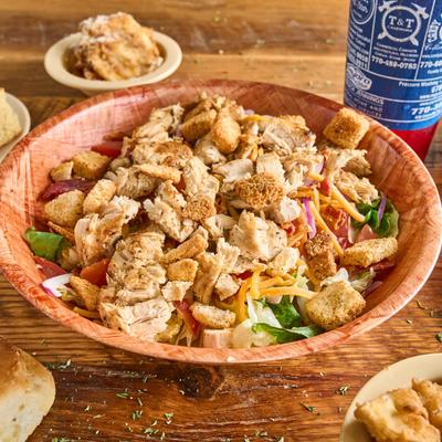 Grilled Chicken Salad with peppers, onions, tomato, cheese, bacon, cucumbers, and croutons.