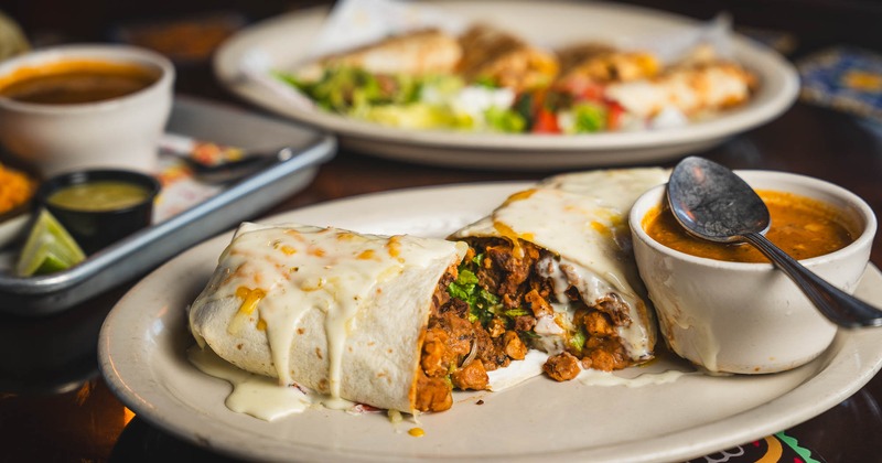 Burrito plate with assorted food plates behind it