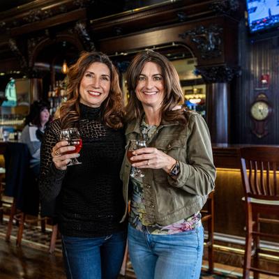 Two people posing with drinks.