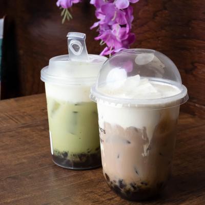 Two bubble teas served in clear, disposable plastic cups.