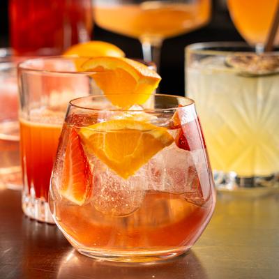 Strawberry Aperol Spritz with other colorful cocktails in the background.