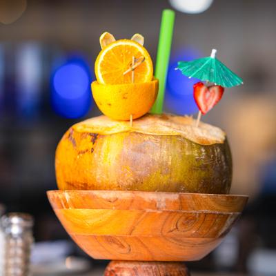 Tropical drink served in a coconut with fruit garnish.