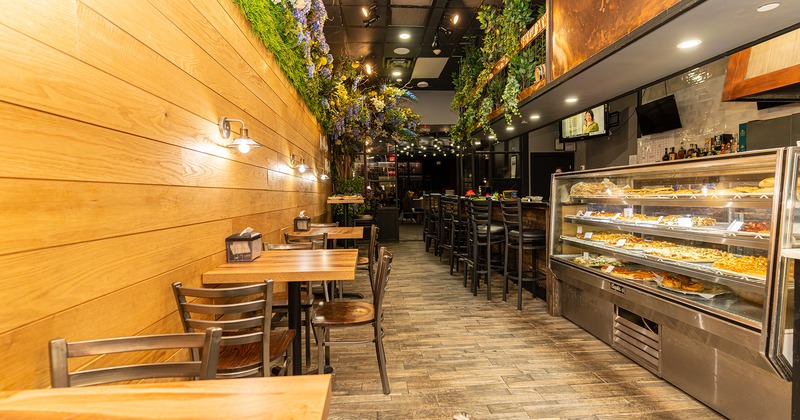 Interior space, dining tables lined up by the wall near the bar area