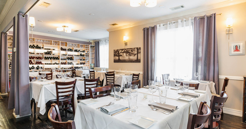 Interior, set tables ready for guests, wine shelves
