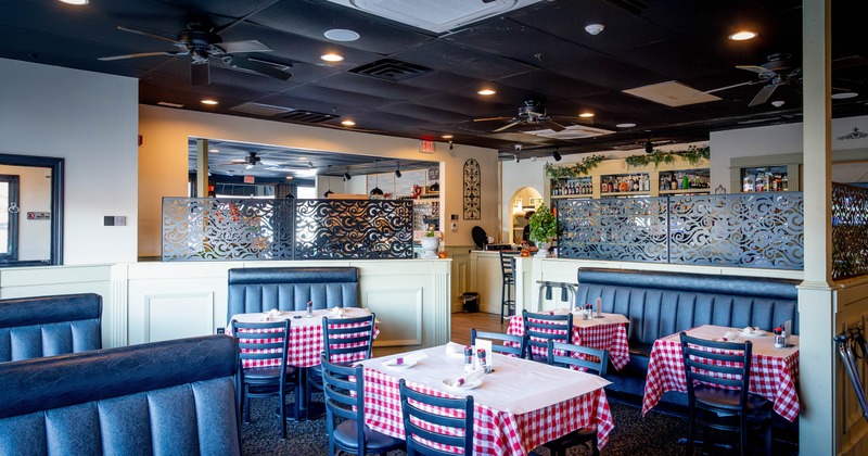 Interior with checkered tablecloths, decorative screens and a visible bar area