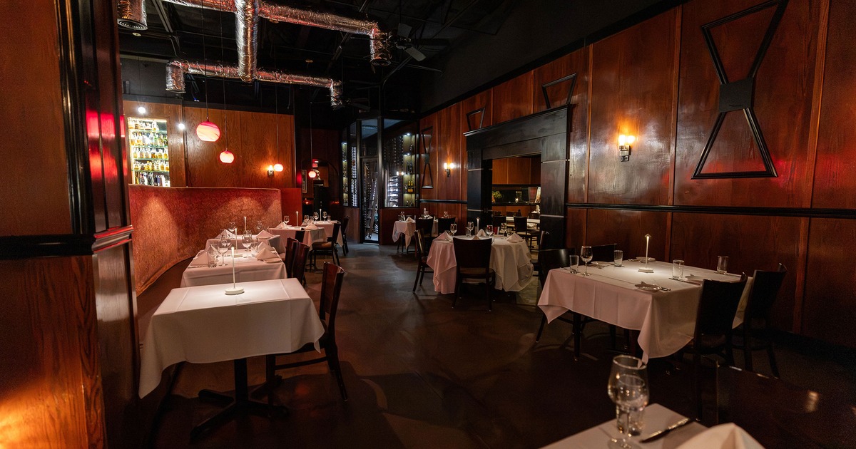 Interior of an elegant restaurant dining room with dining tables set for guests