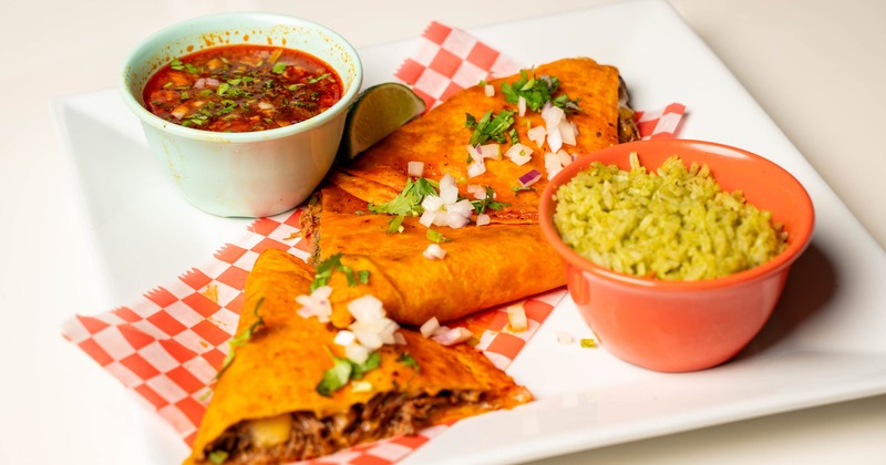 Birria tacos served with green rice and birria broth
