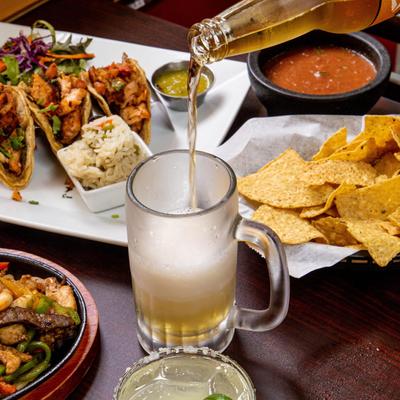 Different types of food and salad on the table, beer in the middle