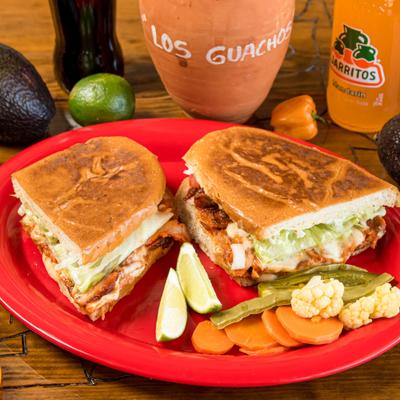 Pork sandwich, with melted cheese, tomato, lettuce, mayo, beans, onion and avocado