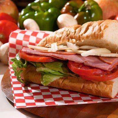 Italian sub sandwich with baked ham, salami, provolone cheese, and tomatoes.