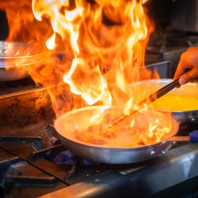 A pan with flame bursting from it.