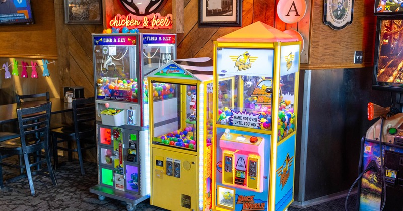 Arcade corner with three colorful claw machines filled with toys and balls
