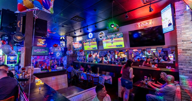 Interior, booths, bar behind, screens above