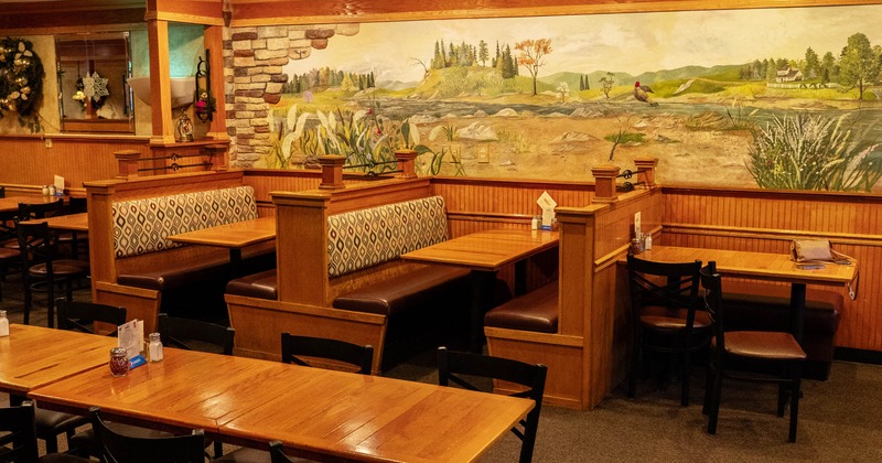 Empty restaurant interior with wooden booths and dining tables
