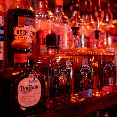 Liquor bottles on a bar shelf.