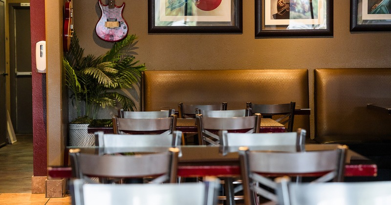 Lined up tables and chairs close up, and upholstered seats by the wall