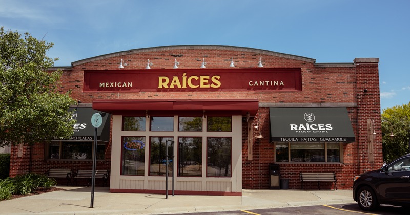 Exterior, front view to restaurant entrance, sign above, parking lot in front