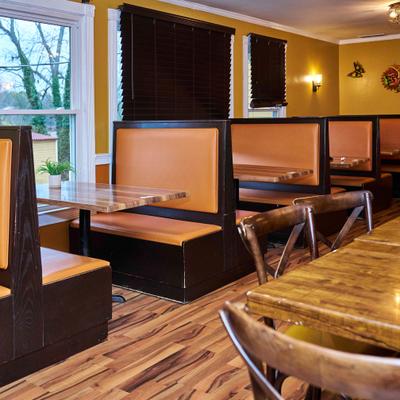 Resturant interior with booth seating and wooden tables.