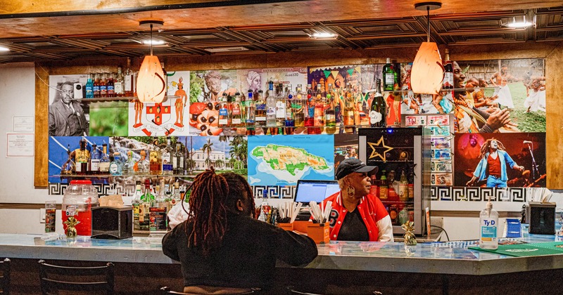 A bar, bartender and guest drinking