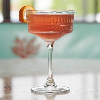 Pink cocktail, orange peel garnish.