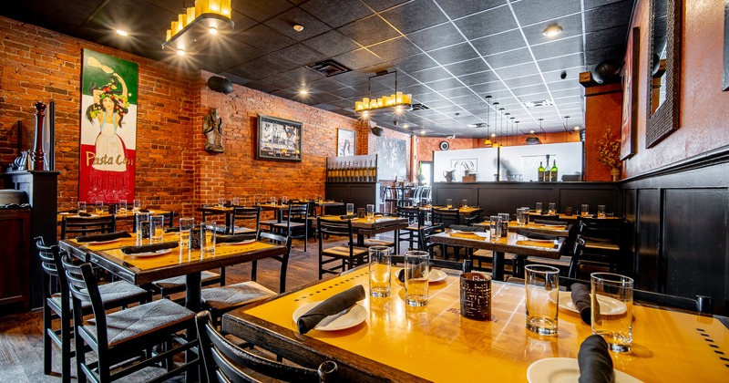 Spacious interior dining area with tables set with glasses, plates, and rolled napkins