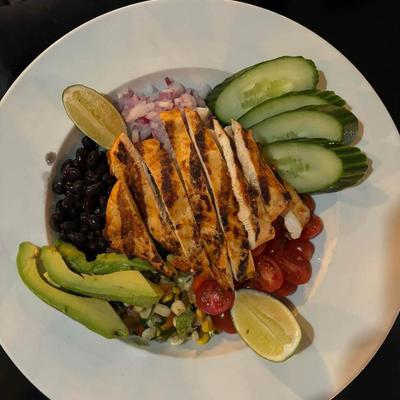 Grilled chicken salad with avocado, black beans, cucumbers, and tomatoes.