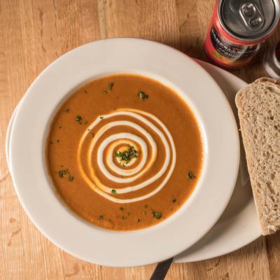 A plate of soup served with sourdough slice.