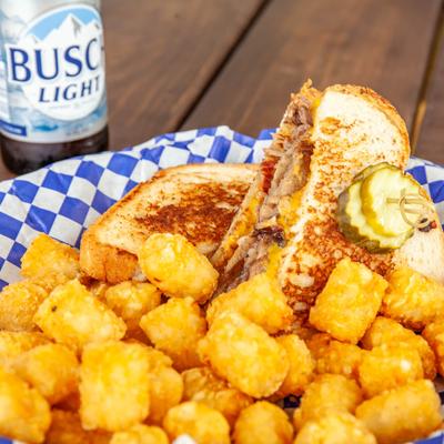 Grilled brisket and cheese sandwich, and tater tots.
