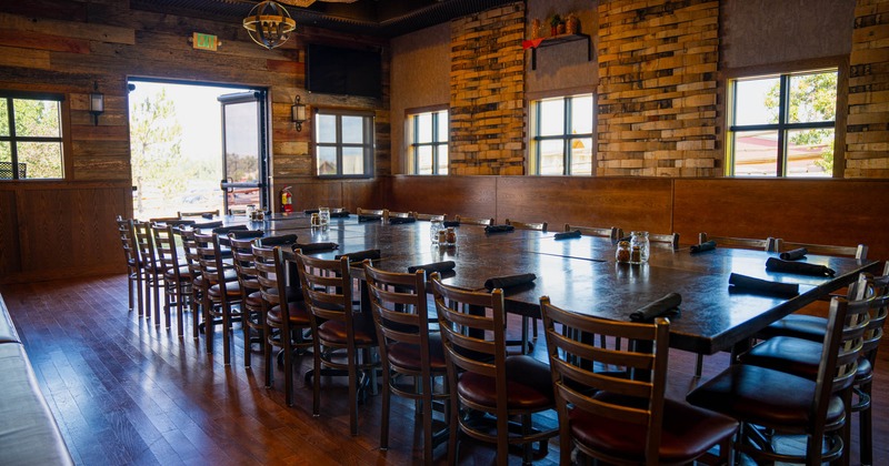 A rustic dining room with a large table and wooden chairs