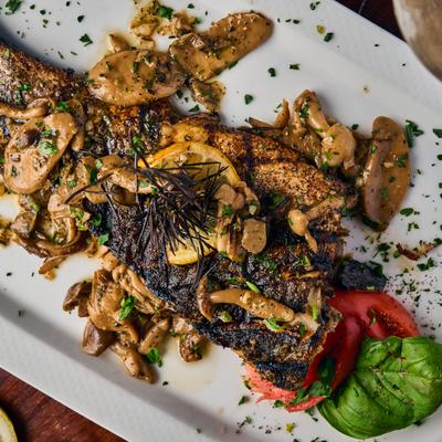 Plated food with mushrooms, herbs, and red bell pepper slices.