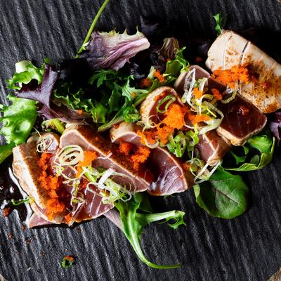 Thin sliced seared tuna with yuzu wasabi dressing topped with massago and scallion.