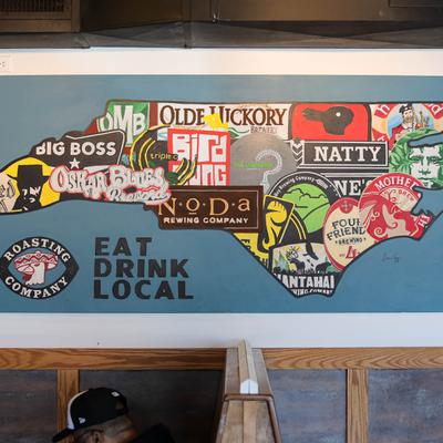 Colorful mural of North Carolina featuring local brewery logos.