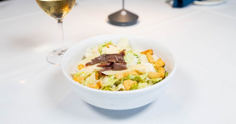Caesar salad topped with anchovies and croutons