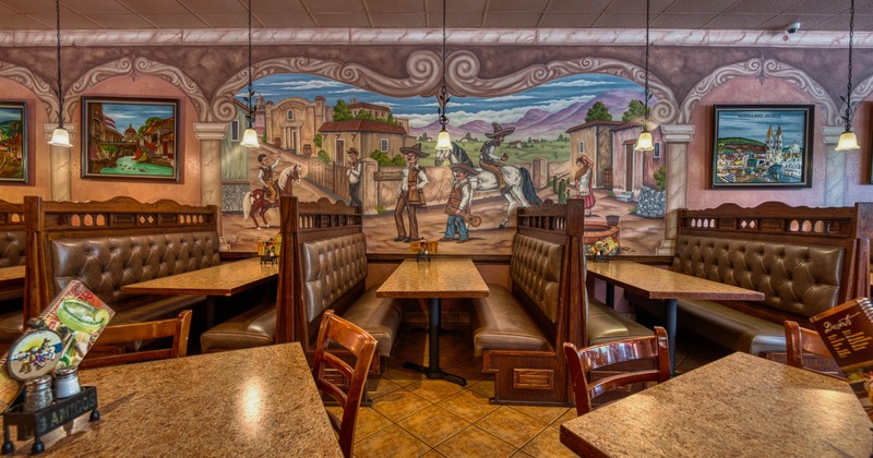 Interior seating area with chairs, tables and double booths, traditional mural on the wall