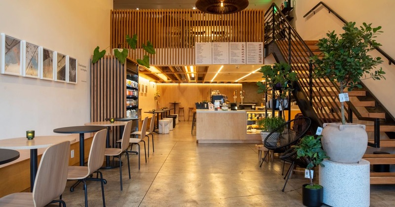 Contemporary cafe interior with wooden accents, ample seating, and a central counter